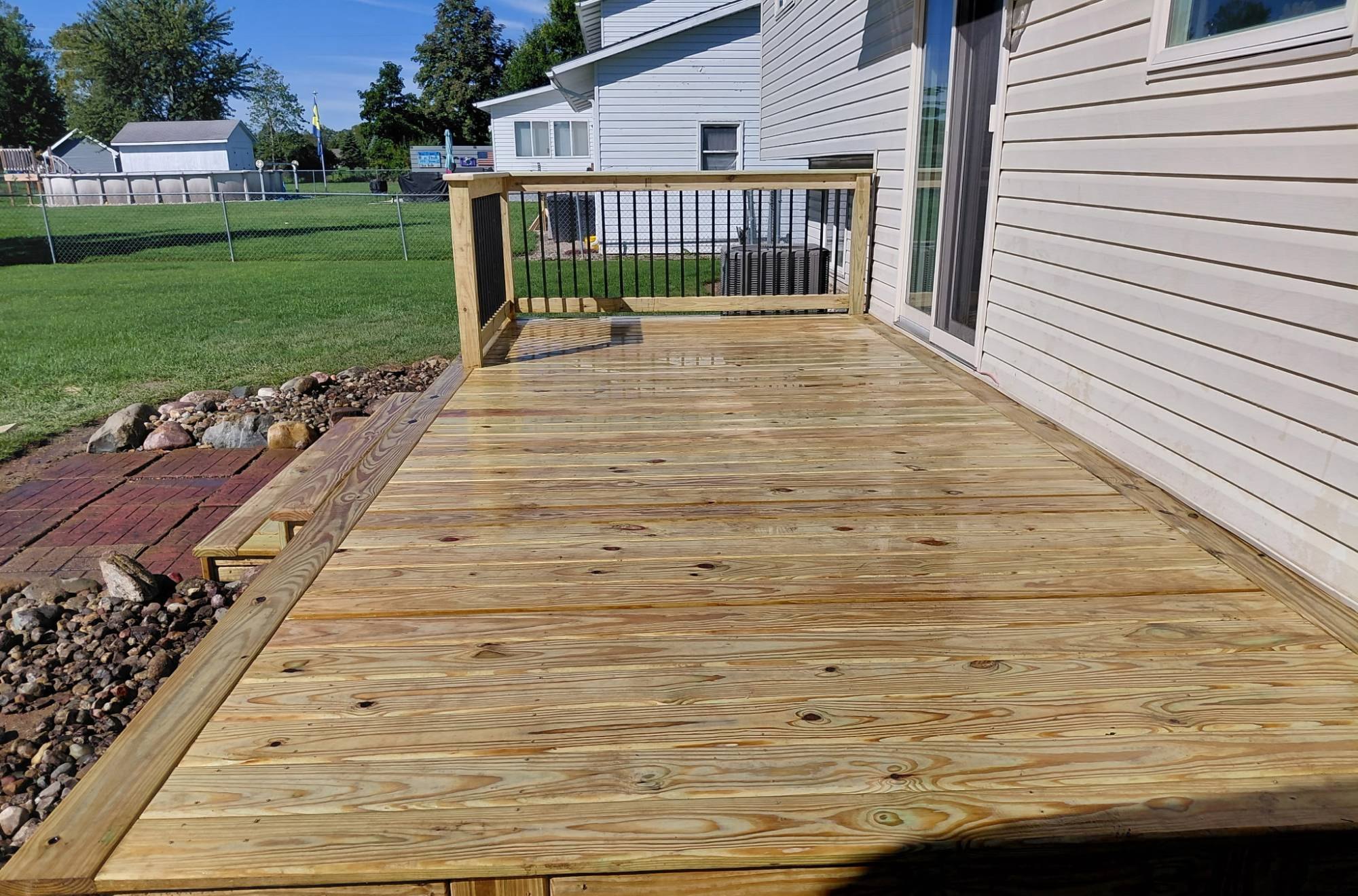 Deck surface looking toward the railed corner, with the picture-frame border running along the edge