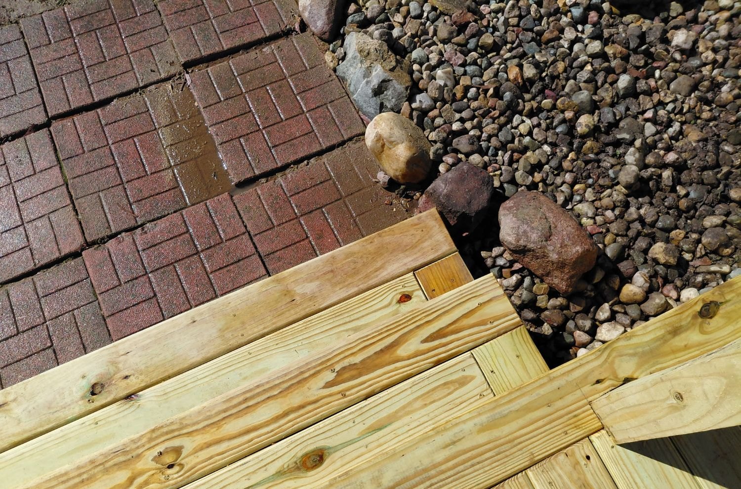 Corner detail where the steps meet the brick paver patio and stone border